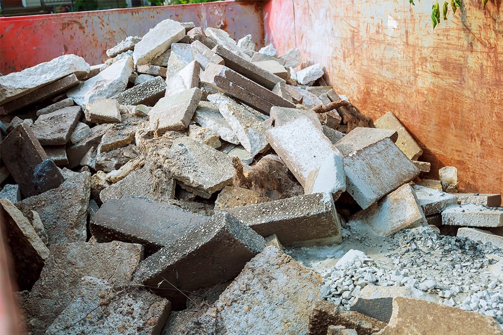 Concrete rubble and blocks inside a red skip