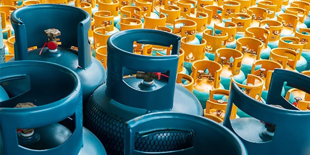 Multiple gas cylinders arranged in rows, representing hazardous waste