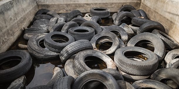 Discarded car tyres piled in a holding area