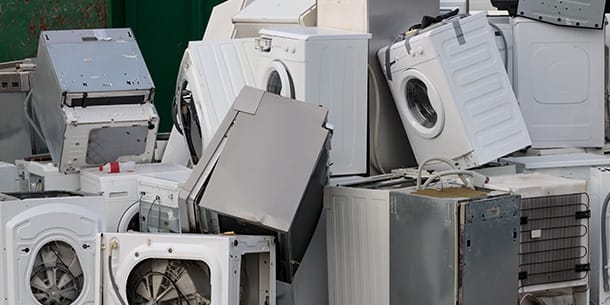 Pile of discarded white goods including washing machines and fridges